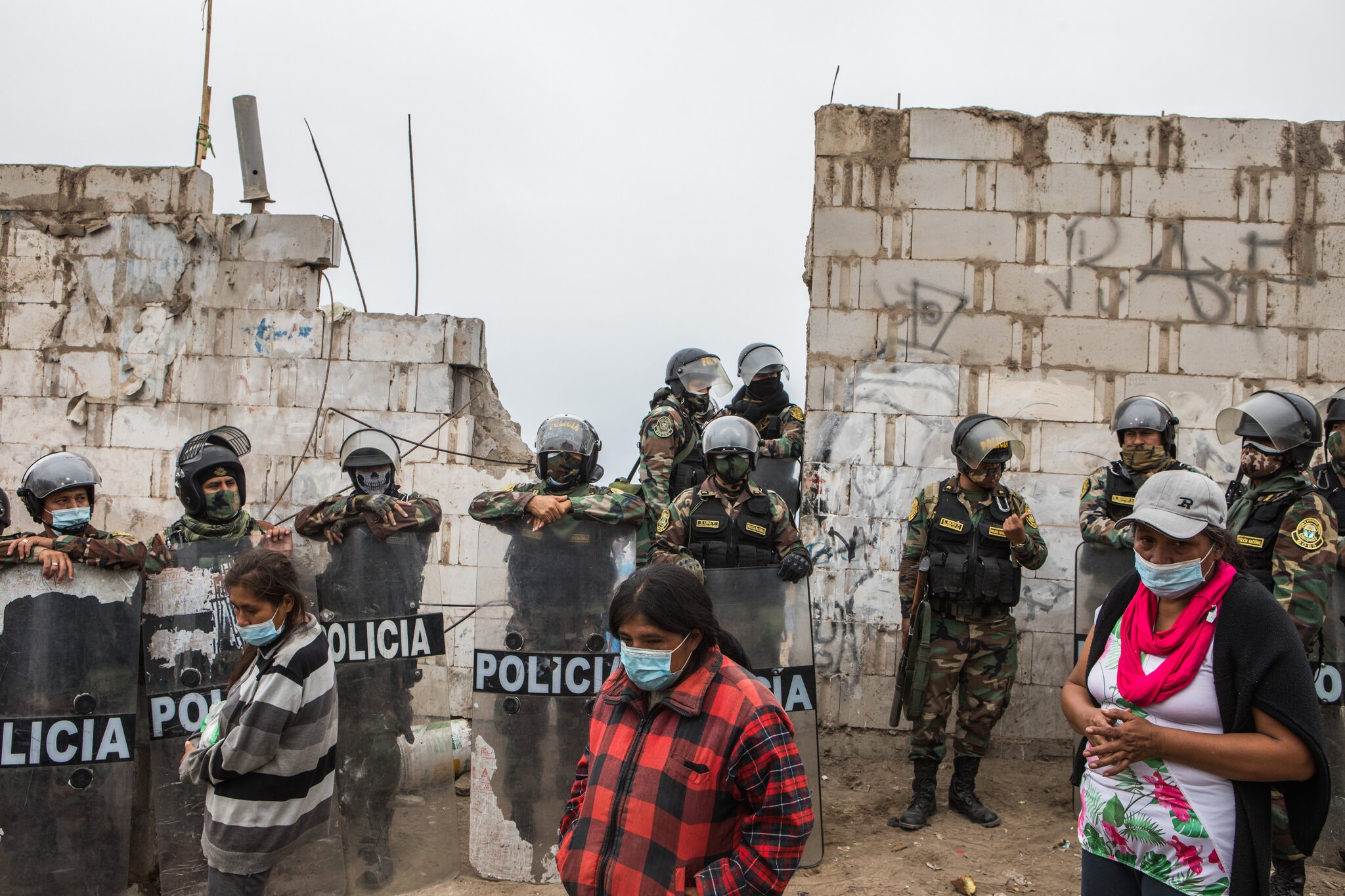 La policía desalojó a un grupo de personas que ocupaba terrenos públicos y privados en Lima. Foto: Marco Garro para The New York Times