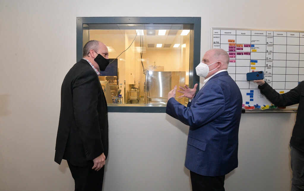 El gobernador de Maryland, Larry Hogan, a la derecha, da un recorrido por Emergent en febrero de 2021 antes de que salieran a la luz los problemas de producción.