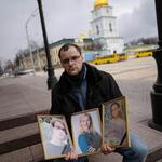 VÍCTIMAS. Serhiy Perebyinis sostiene retratos de su esposa y sus hijos Mykyta, de 18 años, y Alisa, de 9, asesinados por fuego de mortero ruso.