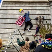 VIOLENCIA. Una turba de simpatizantes de Trump escalan un lado del Capitolio en Washington el miércoles 6 de enero de 2021.